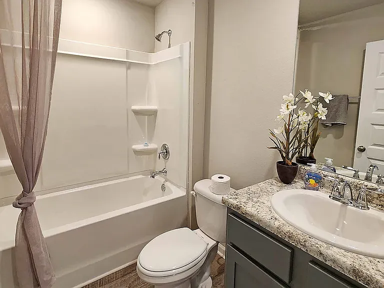 Second bathroom, includes one sink & vanity with storage underneath. Bathtub and shower combined.