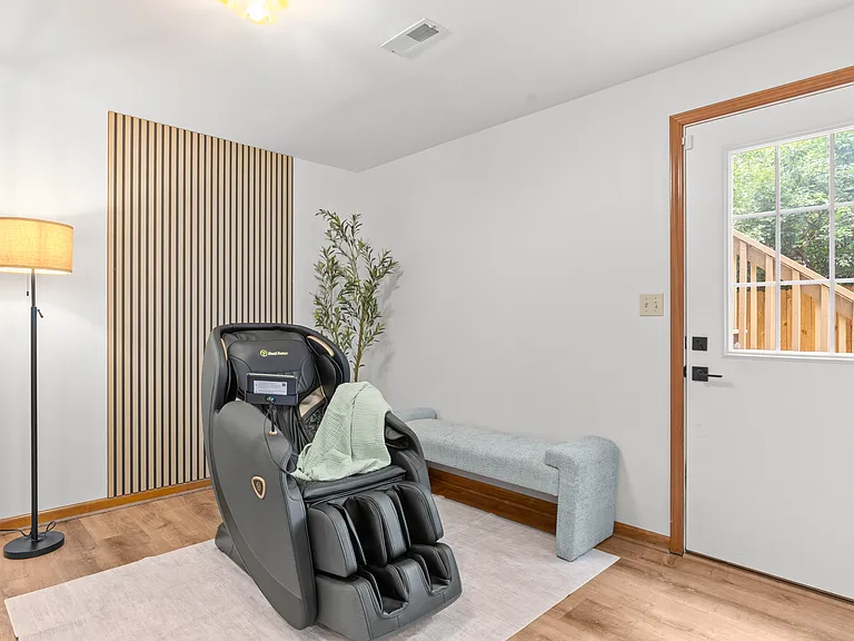 Relaxing basement corner with a full-body massage chair and comfortable seating, perfect for unwinding at the end of the day.