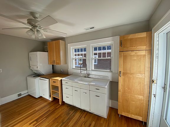 Sunny kitchen with DW, W/D, stove, and refrigerator. Door to back porch on right; dining room to the left