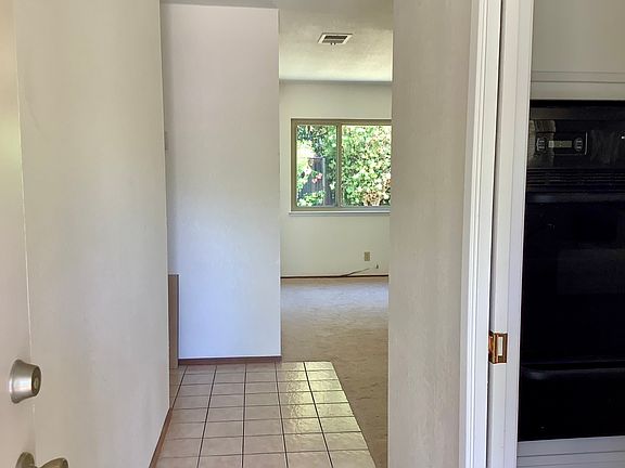 Entrance Hallway. Kitchen through the pocket door to the right. Living room in front with beautiful backyard view. Bedrooms down the hall to the left.