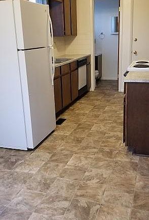 From dining area towards kitchen and half bathroom, with door to garage on left.
