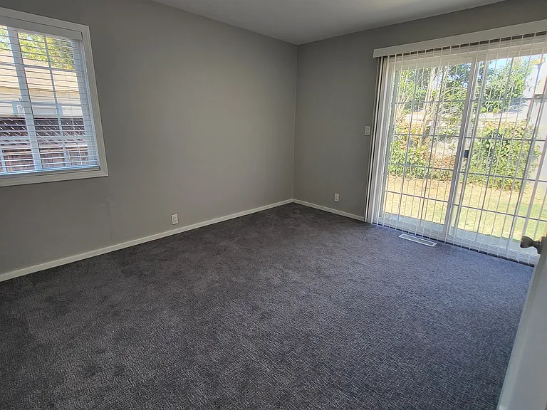 Bedroom #1 with new paint, blinds, carpeting, and lighting.