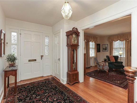 High ceilings, wide base boards, coat closet, leaded glass side lights and square archways separate the formal living and dining rooms.