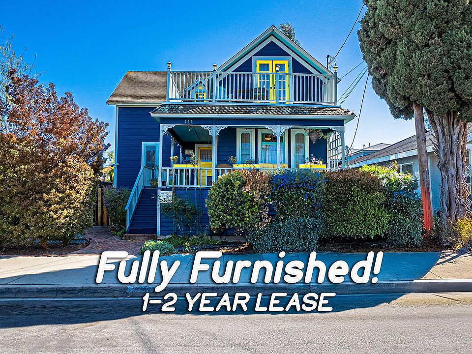 The front of the home features a charming blue exterior accented with cheerful yellow details, creating a warm and welcoming first impression.