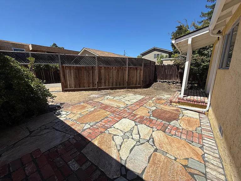 Private relaxing backyard with brick and stone pavers.