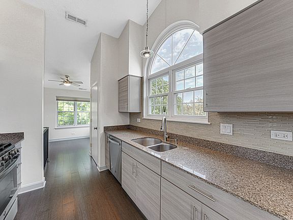 Kitchen: A modern kitchen with sleek appliances, countertops, and cabinets, shown from different angles (three photos).