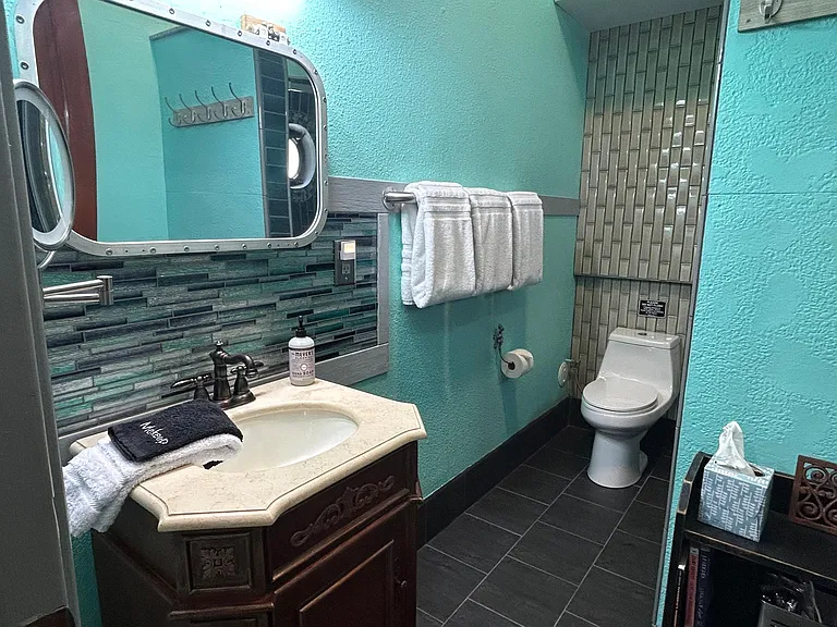 Uniquely tiled full bathroom with nautical accents.