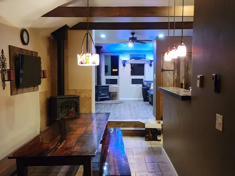 Dining room, (handmade barn wood table). Holds 8 easily. Colored Stained glass chandelier. The living room at the far end.