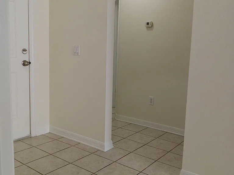 View from the laundry room looking to the hallway leading to 2 bedrooms and guest bath.