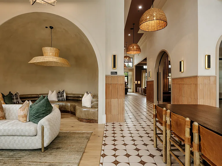 Luxury apartment clubhouse with designer lounge seating, community gathering spaces, and warm modern interiors.