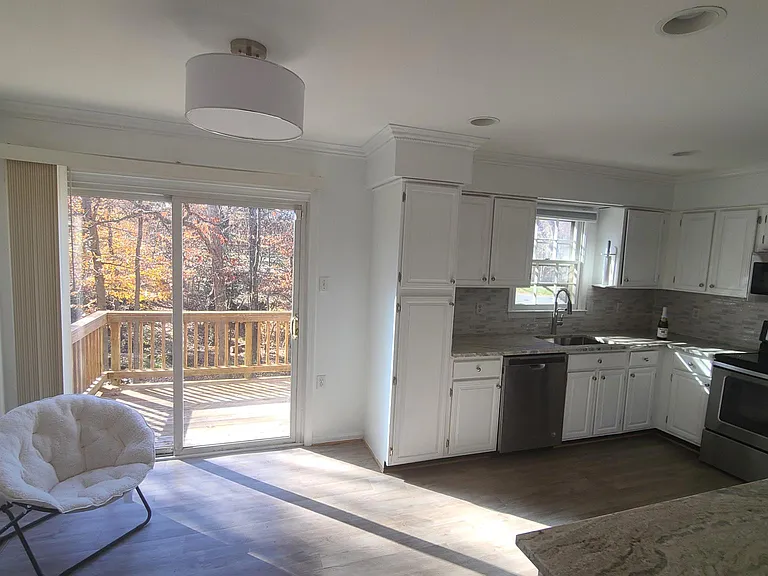 Kitchen entry from main hallway. Full size wooden deck facing serene private wooded lot.