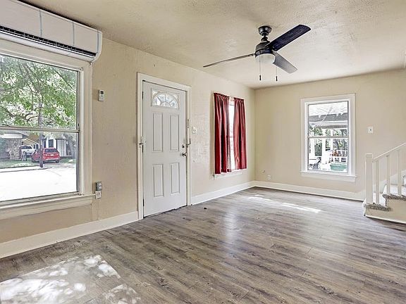 Living area with laminated flooring and nice windows.