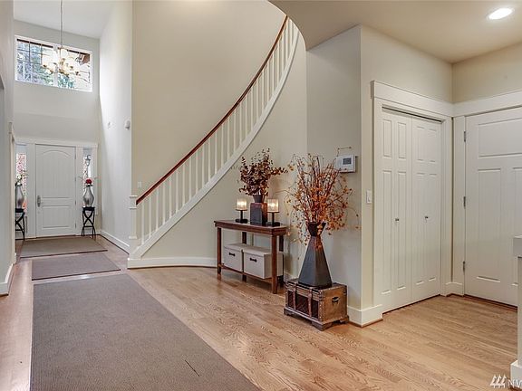 Here's another view of the gorgeous entry with two chandeliers. Gleaming hardwood floors flow from the entry to the dining room, kitchen and informal dining areas. To the right is a door leading to the 3-car tandem-style garage and a walk-in closet under the stairway. You can see the high ceilings here as well!