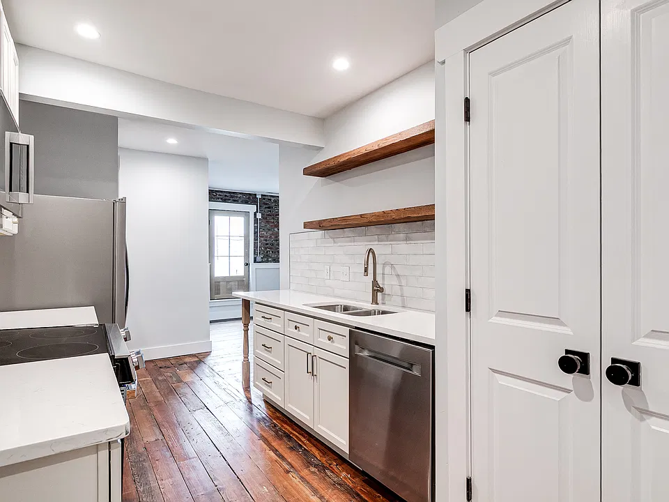 Enter the apartment into the galley kitchen. The large pantry is to the right of the dishwasher seen in this view.