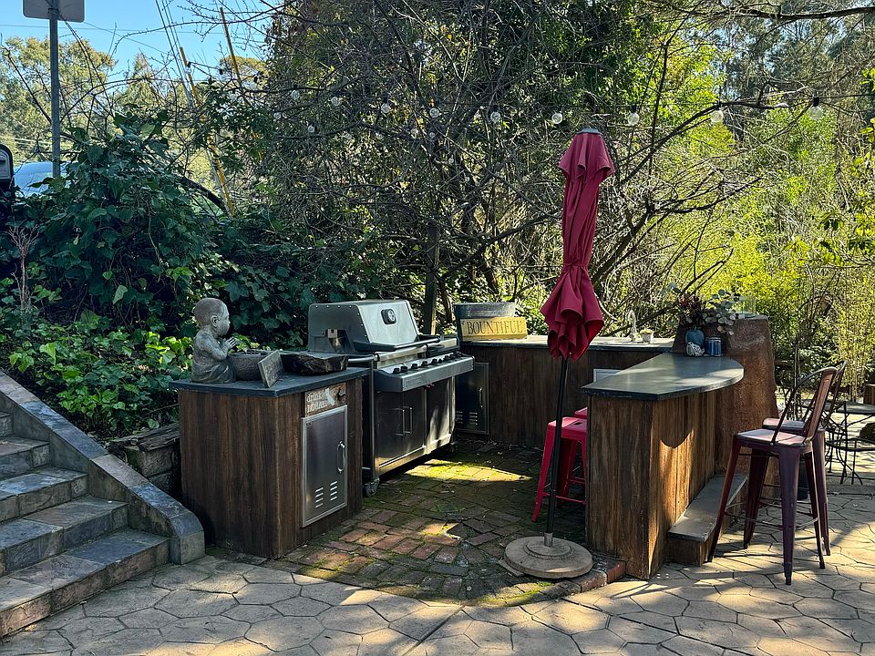 Outdoor kitchen includes gas grill.
