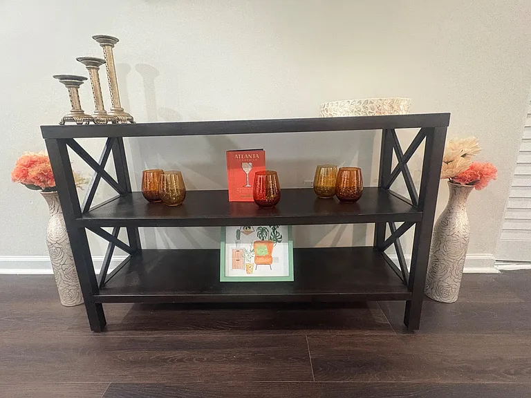 Common area with a console table and display shelving, ideal for shared storage and decorative accents.