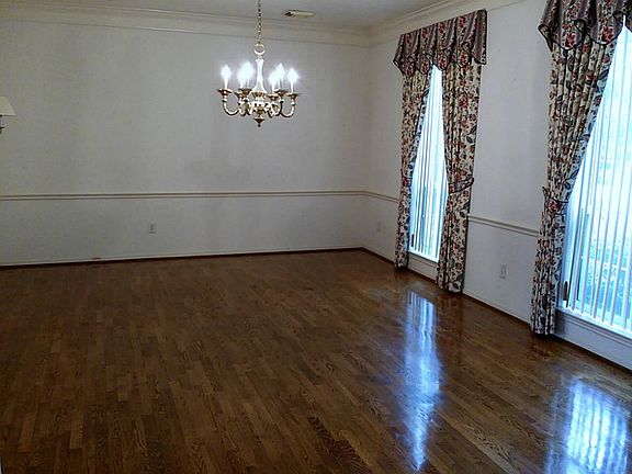 A closer look at this Formal Dining Room w/gleaming hardwood floors & tall windows to let in the sunshine.