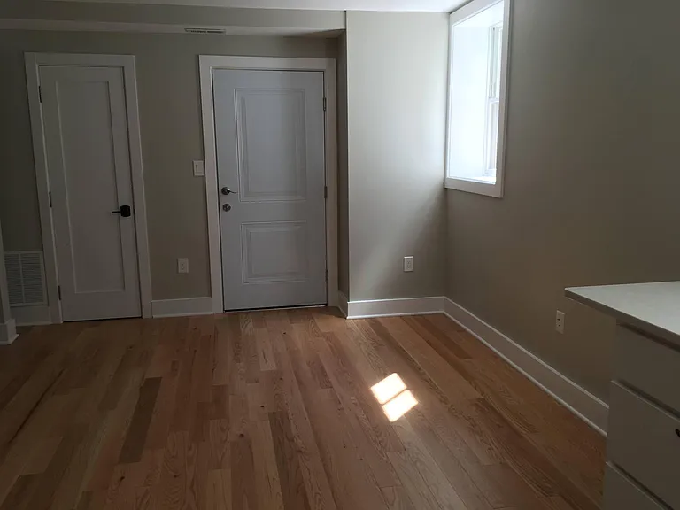 Great room view taken from kitchen area. Entry door on right, coat and pantry closet on left.