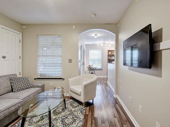Living room, sofa, coffee table and chair, 48" TV. Upstairs hallway leading to outdoor deck.