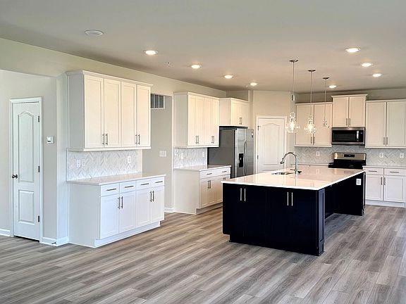 Navy island white cabinets in a DRB Homes Emory II home in the Tinker s Preserve community.