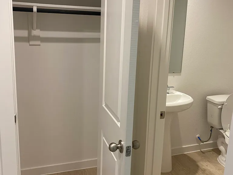Coat closet and half bathroom located by guest bedroom 3 and garage