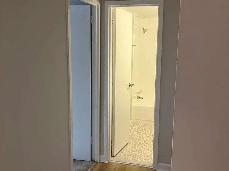 Hallway to bedroom to bathroom with tub