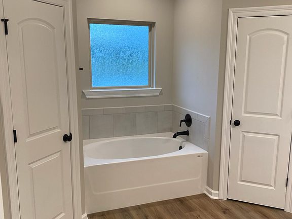 Master bathroom soaker tub between his and hers walk in closets