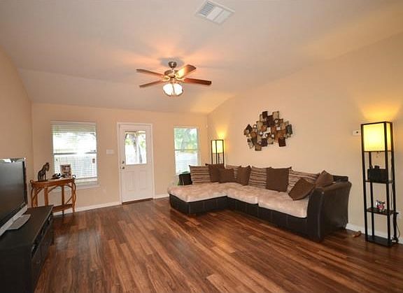 The large family room includes high ceilings and easy-to-maintain laminate flooring.