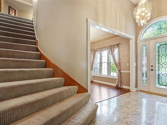 Grand stair case just past the entryway and before entering the Living Room.