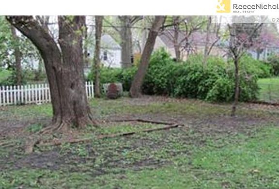 Spacious fenced yard with mature trees.