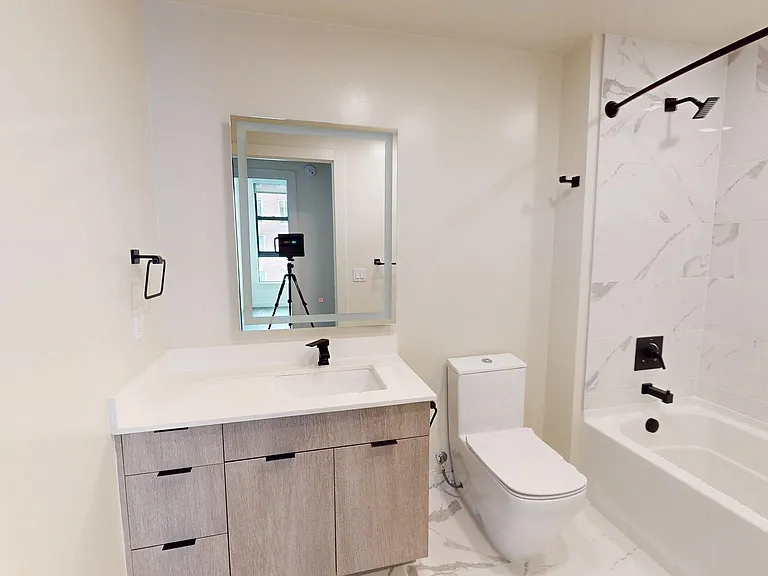 Apartment bathroom with tile flooring.