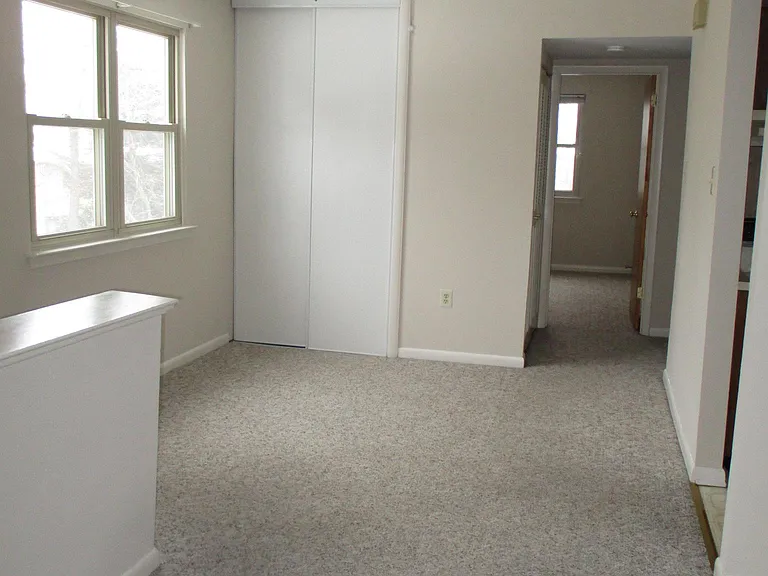 Smaller bedroom is seen at the rear of the house.