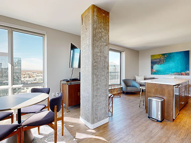 Apartment dining and living room with wood-style flooring.
