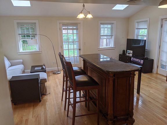 Open living dining area with 2 skylights and door to private courtyard