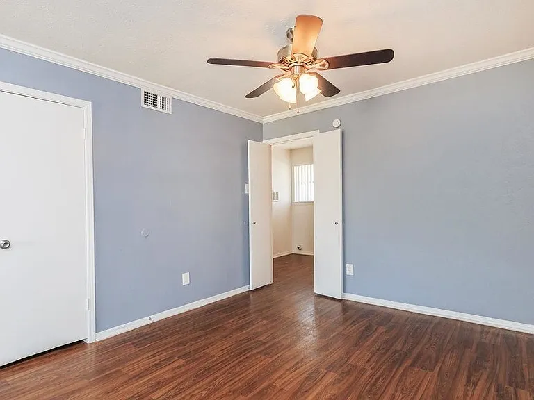 Modern bedroom with ceiling fan and roomy closet_perfect blend of comfort and practicality.