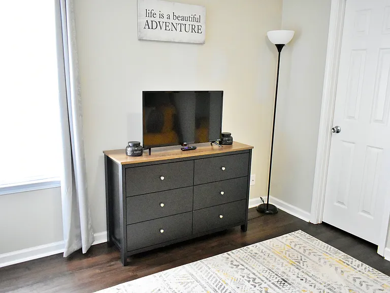 A dresser is provided for storage. The TV is a smart TV.