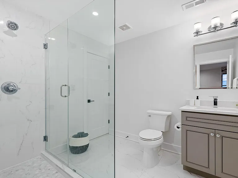 Full bath with a frameless shower, connecting Bedroom A and living room