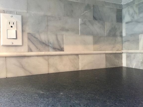 Marble backsplash and suede, black granite countertops.