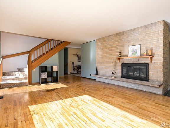 Who wouldn't enjoy this large freshly painted living room with the custom made railing.  Sun reflects from the original hardwood floor to the wall and above the fireplace mantle.  So light and bright.