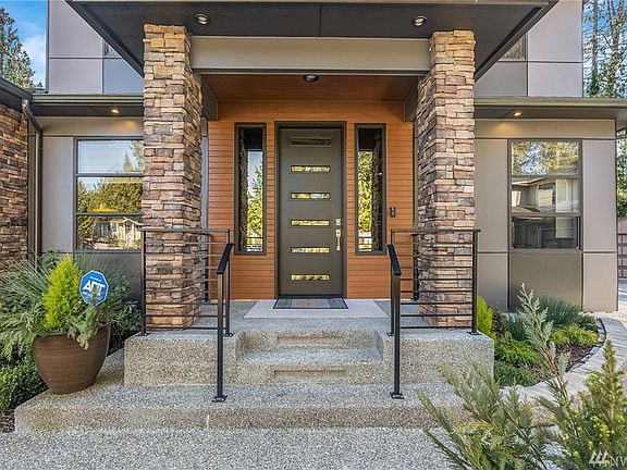 The moment you step into the entryway, the home is well lit and inviting.  The exterior media is cement backed siding, cedar boards, and stone.  The aggregate stairs and metal railing detail make this covered entryway picture perfect!