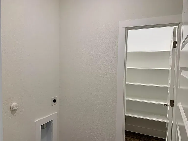 Dedicated laundry room has walk in storage closet with an abundance of shelves.