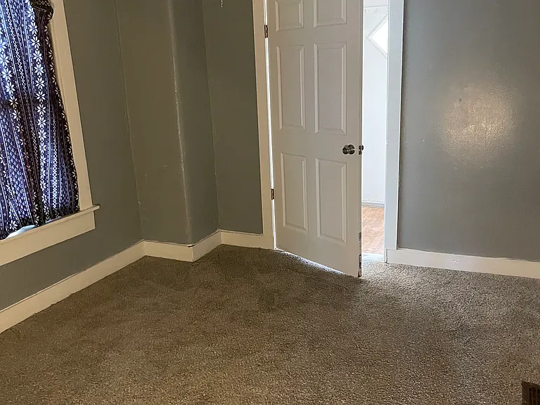 Downstairs Carpeted Bedroom between Breezeway and Full Bath