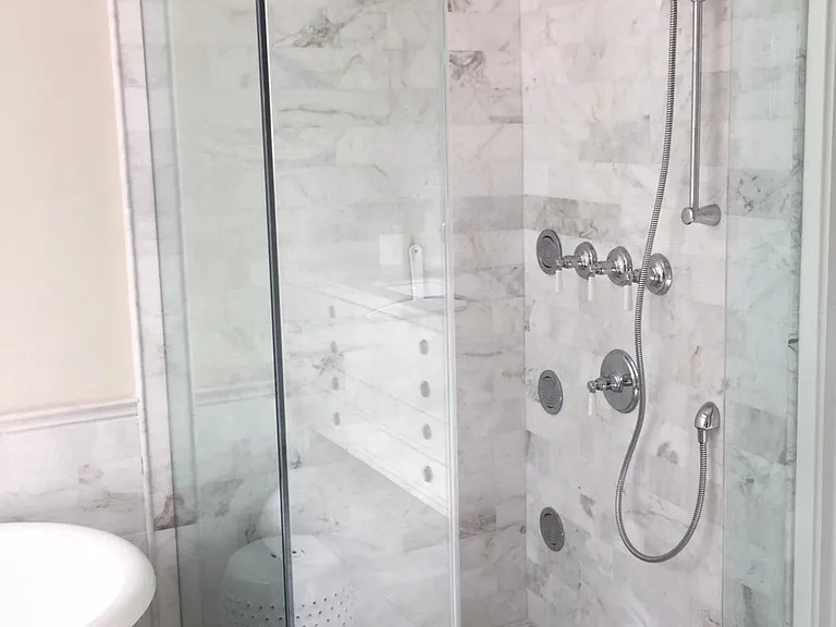 Walk in shower with body spray and waterfall shower head.