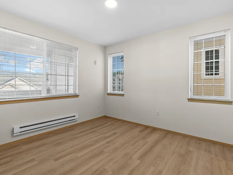 Bright and welcoming bedroom with multiple windows. Bright and welcoming bedroom with multiple windows.