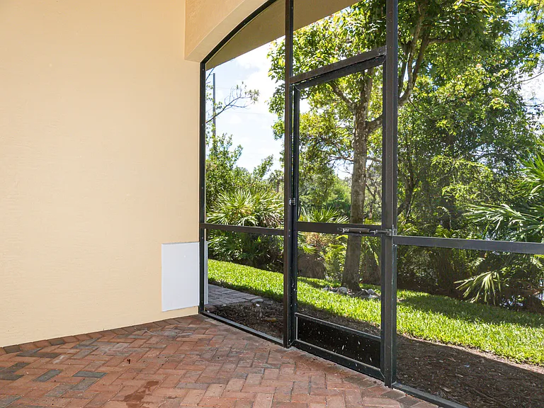 Screened patio with ceiling fan and screen door access to rear yard