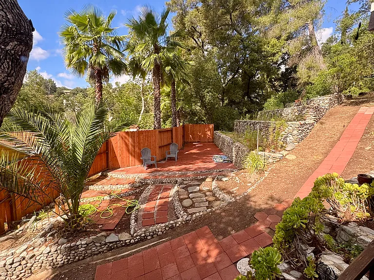 New private lower patio with pavers. Garden planters face 180 degrees south, with 3x larger planters behind the cabin. This view is from the 7' wide living room window.