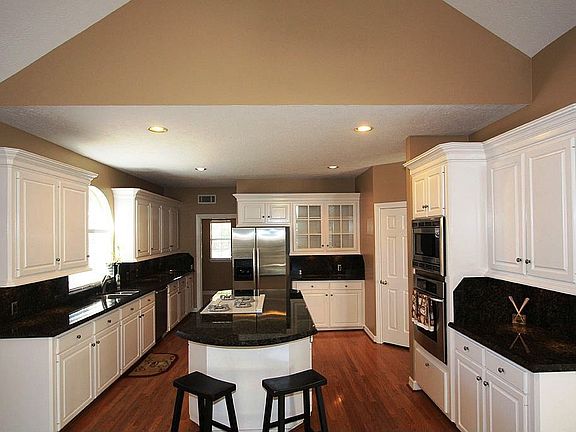 Kitchen features ss appl. gas cooktop, hardwood floors, granite counters.