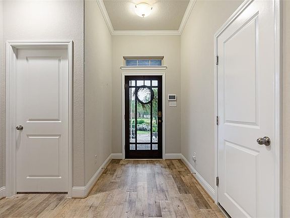 A view of the Entry. Notice the beautiful transom window, large baseboard, and flooring selection.