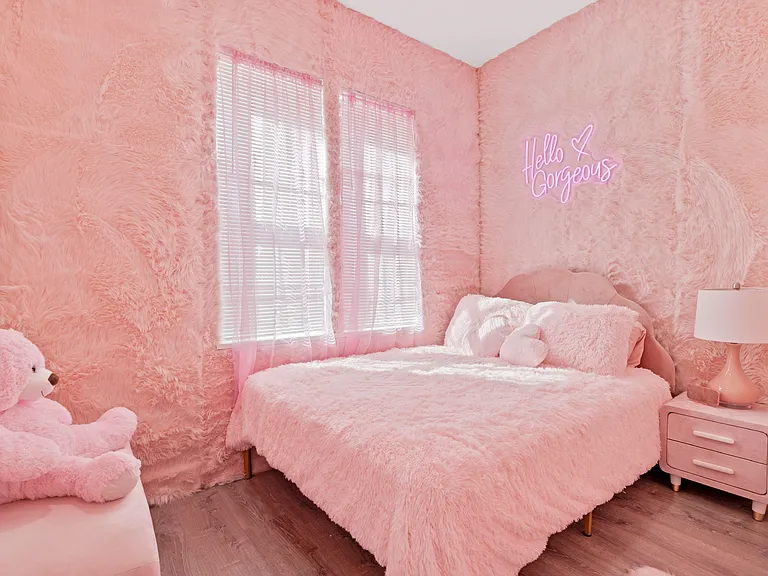 Charming bedroom with a full bed, nightstand and lamp, plus dual windows with blinds for natural light and privacy.