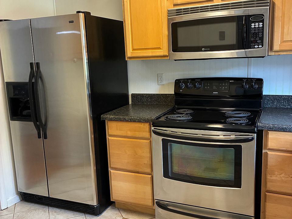 Kitchen with fridge/freezer (ice maker), microwave, and range